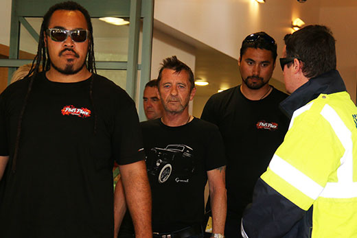 Phil Rudd com seus seguranças saindo do tribunal